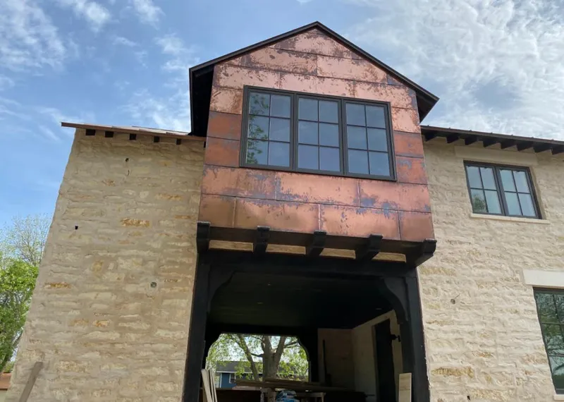 Copper metal panel facade on a stone building for Roof Repair in Manville